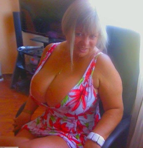 Кудрявая зрелая женщина с силиконовой грудью 